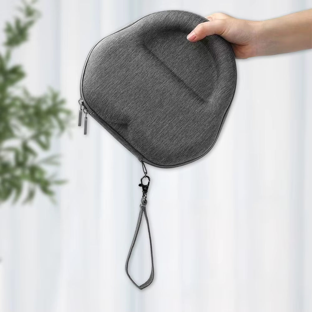 Graues AirPods Max Hardcase mit Trageschlaufe, von einer Hand gehalten, vor hellem Hintergrund.